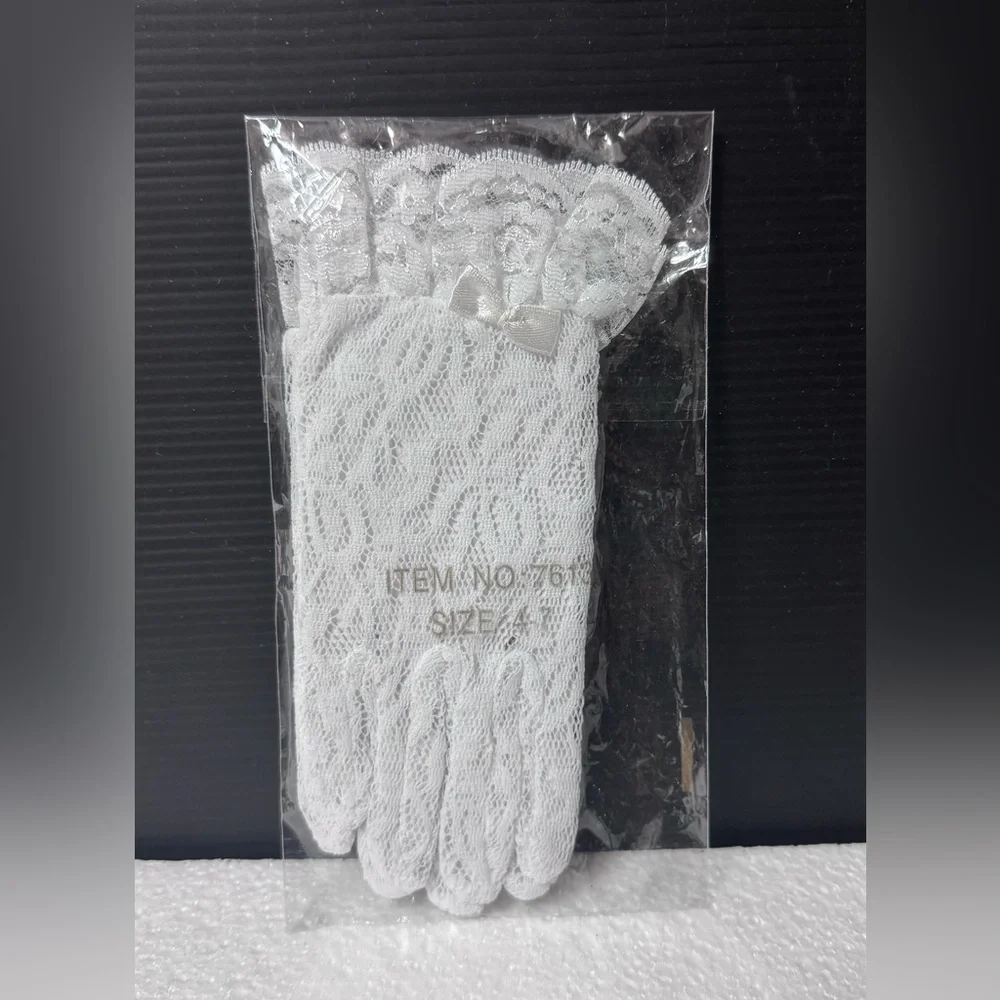 white lace gloves with a bow are labeled for children ages 4-7.